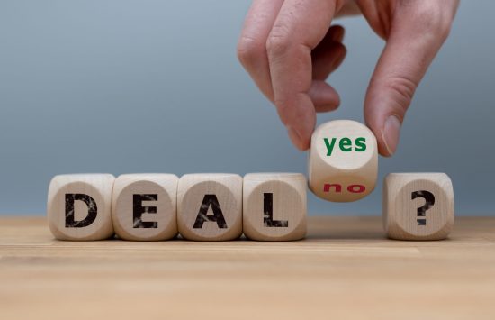 Deal or no deal? Hand turns a cube and changes the word “no” to “yes”. Deal or no deal? Hand turns a cube and changes the word
